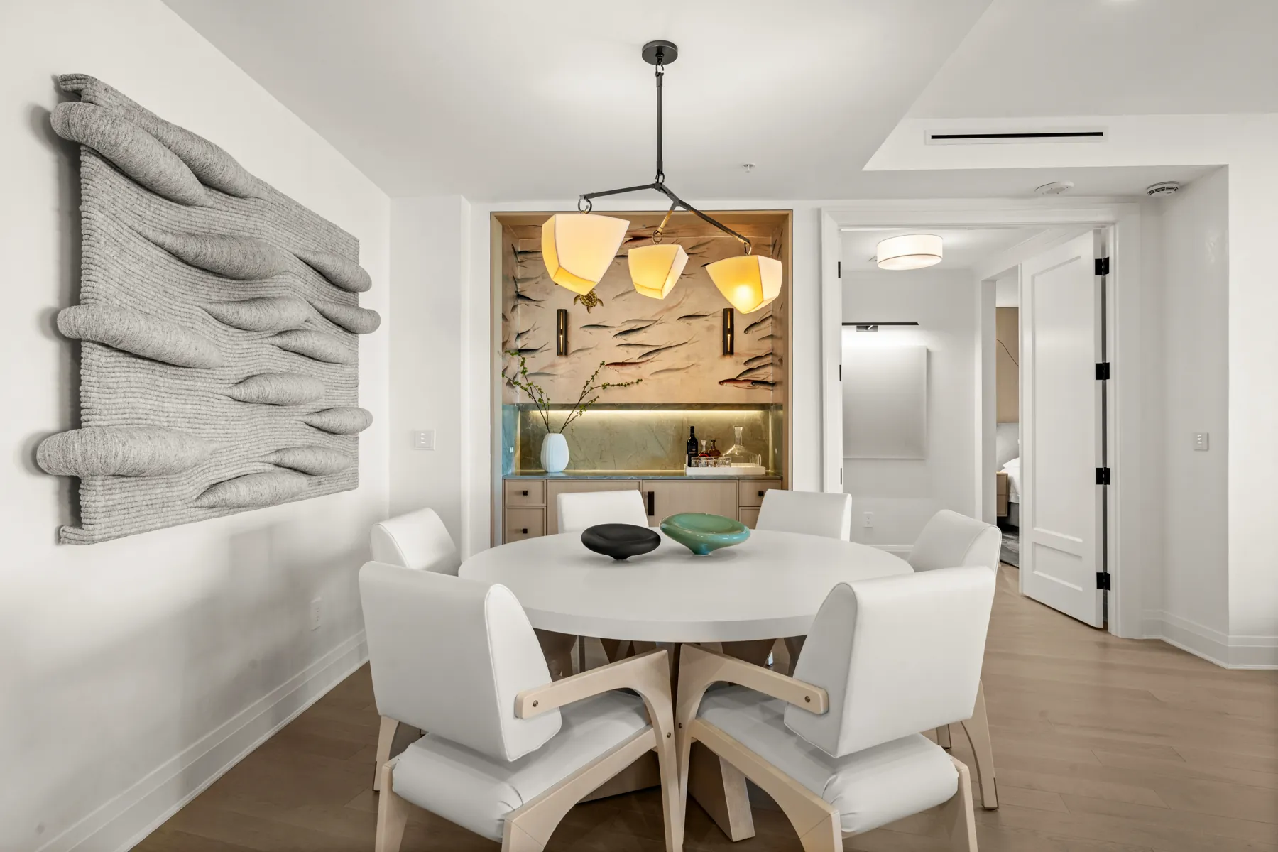 Dining table beneath the sculpted bar wall